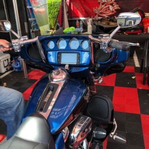 A blue motorcycle parked in front of a table.
