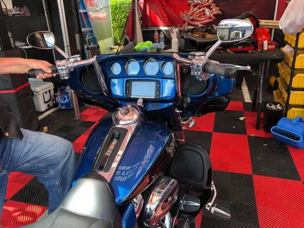 A blue motorcycle parked in front of a table.