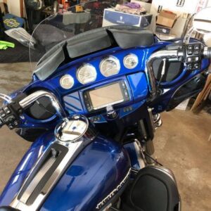 A blue motorcycle parked in a garage with its dashboard.