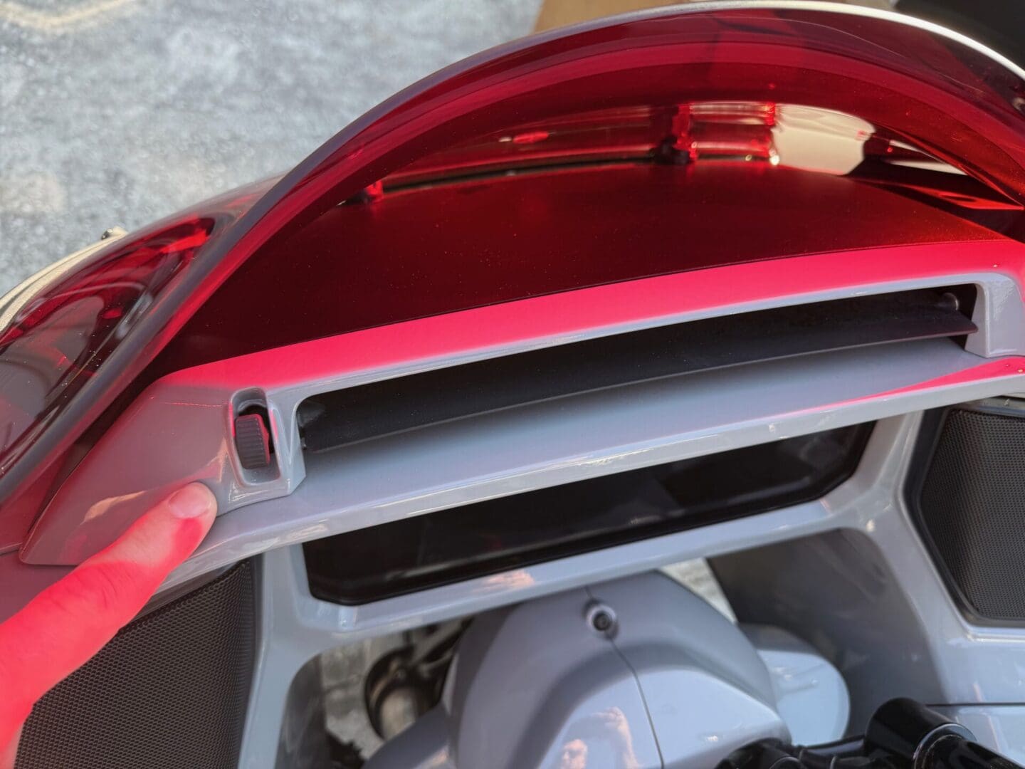 Motorcycle compartment with red tinted cover.